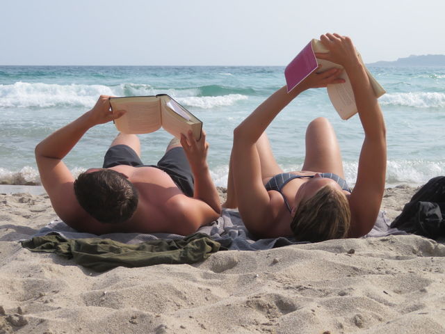 relaxing in summertime with a book in front of sea