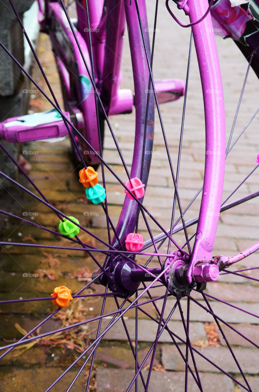 Detail of a purple bicycle, front wheel spokes