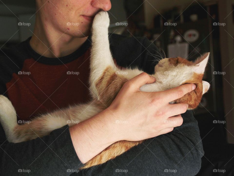 A man hugging a cat young