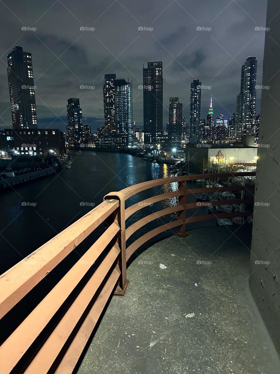 This is “Newtown Creek” at night seen from the “Pulaski Bridge” that connects “Greenpoint”, Brooklyn to LIC, Queens. In the distance we see “Manhattan” including the “Empire State Building” and the “Kreisler Building”. 2023. Hypnotic Productions