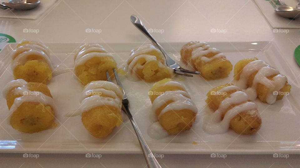 Golden banana in syrup roping with coconut milk,special Thai desert called "gluay kai chuam"