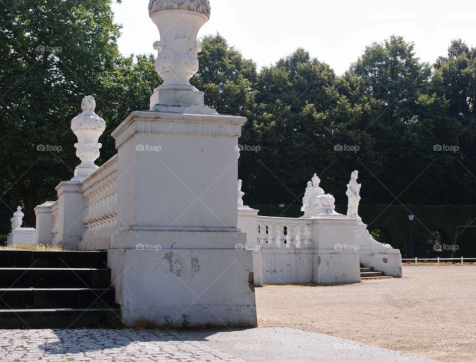 Detailed carved stone railings and a set of stairs in an urban park in Europe on a summer day. 