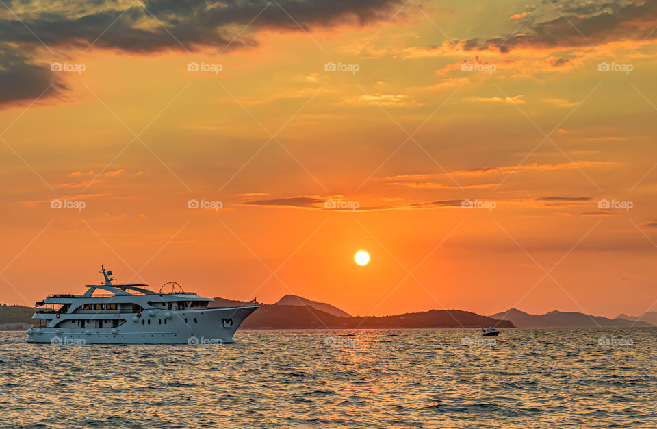 Ship sailing at the sunset