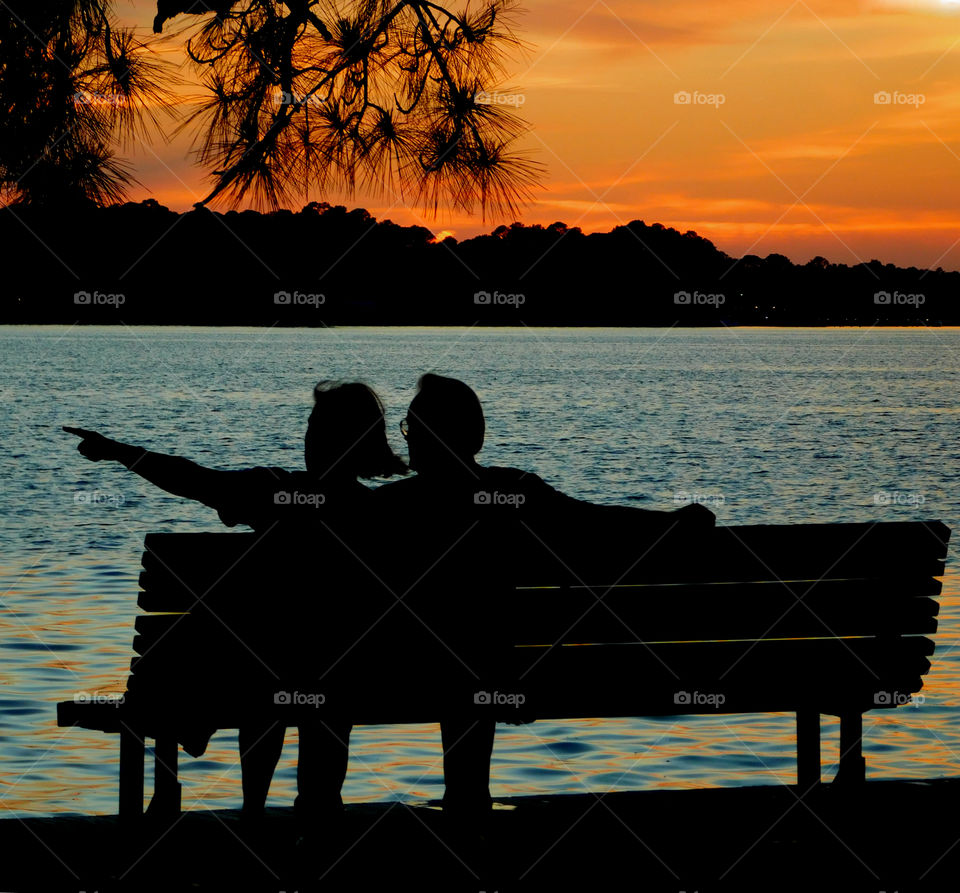 Memorial Day Sunset! A couple relax on a bench in a park during a Memorial Day celebration!