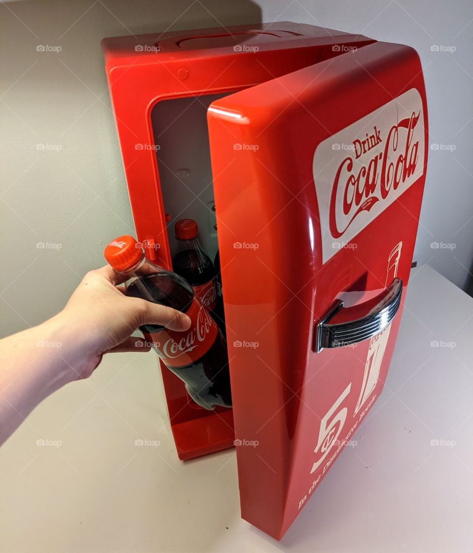 grabbing a Coke from my Coca-Cola mini fridge