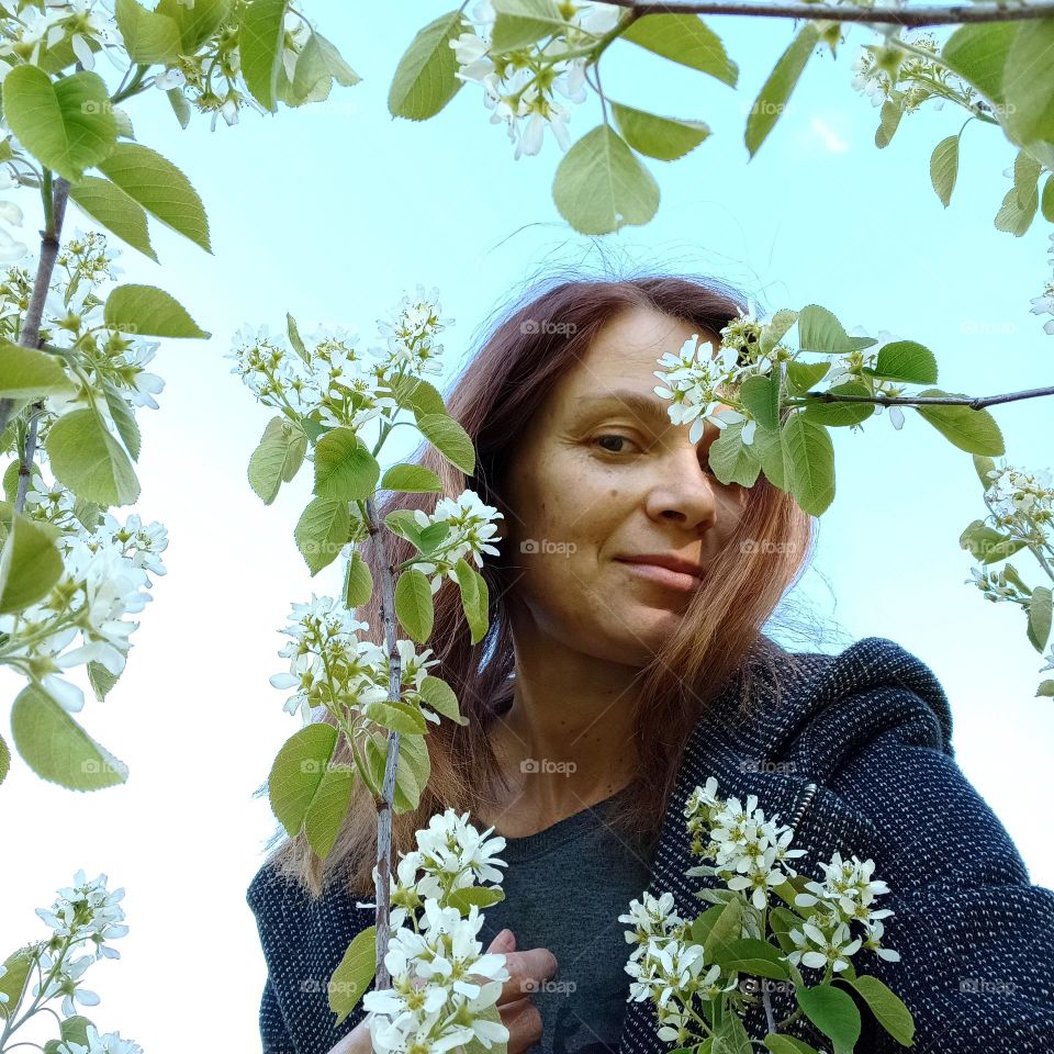 natural woman beautiful portrait with blooming tree white flowers, spring nature, selfie