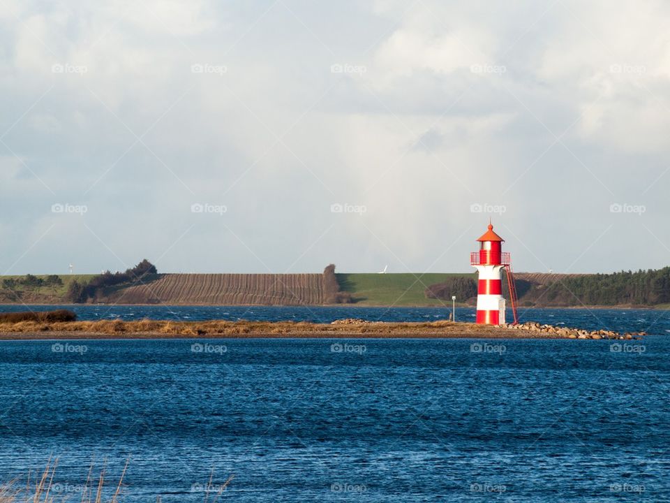 Landscape with red and white lighthouse