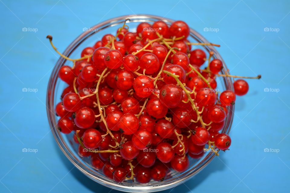 red berries summer food on a plate blue table background