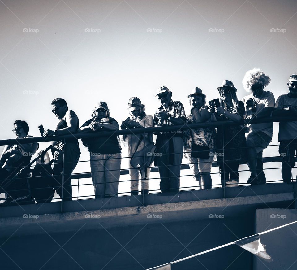 People standing on a bridge looking down