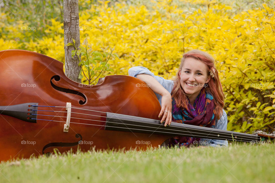 Girl lying on grass with a bass