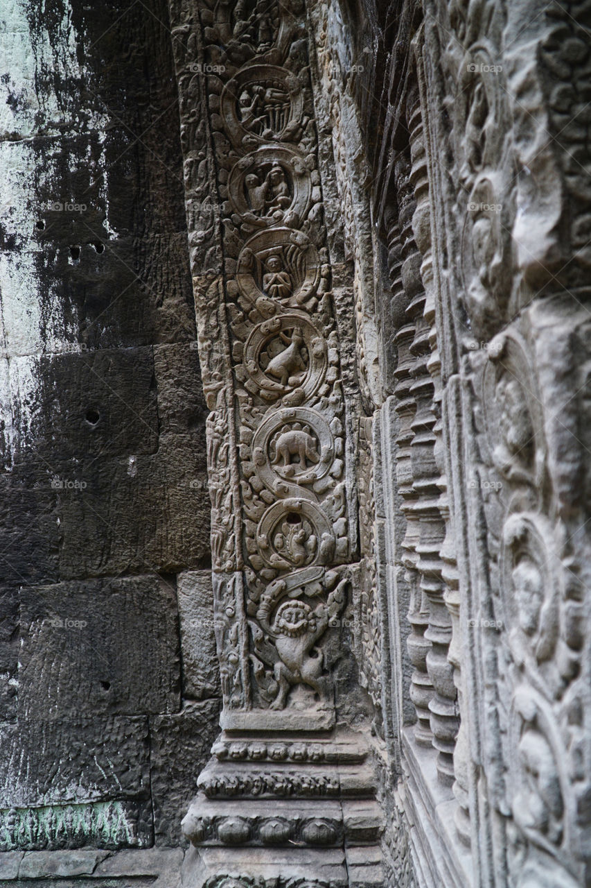 detailed stone carving on the wall of ta phrom temple siem reap cambodia