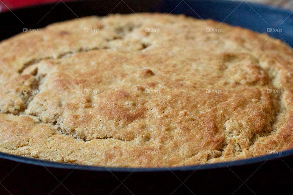 Closeup of freshly baked sourdough cornbread in a cast iron skillet