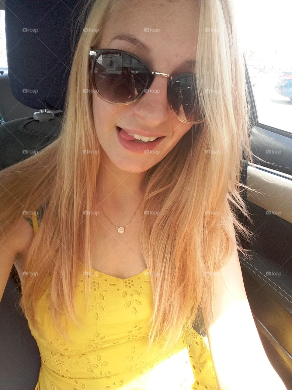 Beautiful blonde girl with sunglasses sitting in car