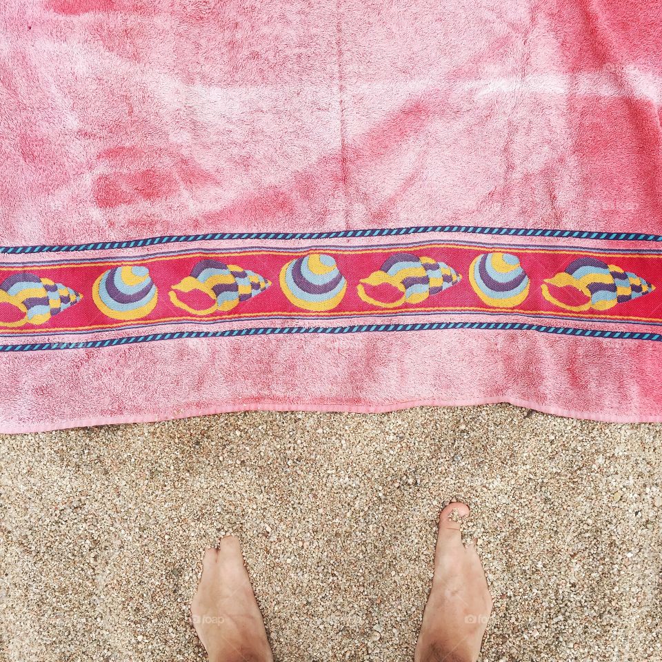 At the beach. Towel, feet and sand