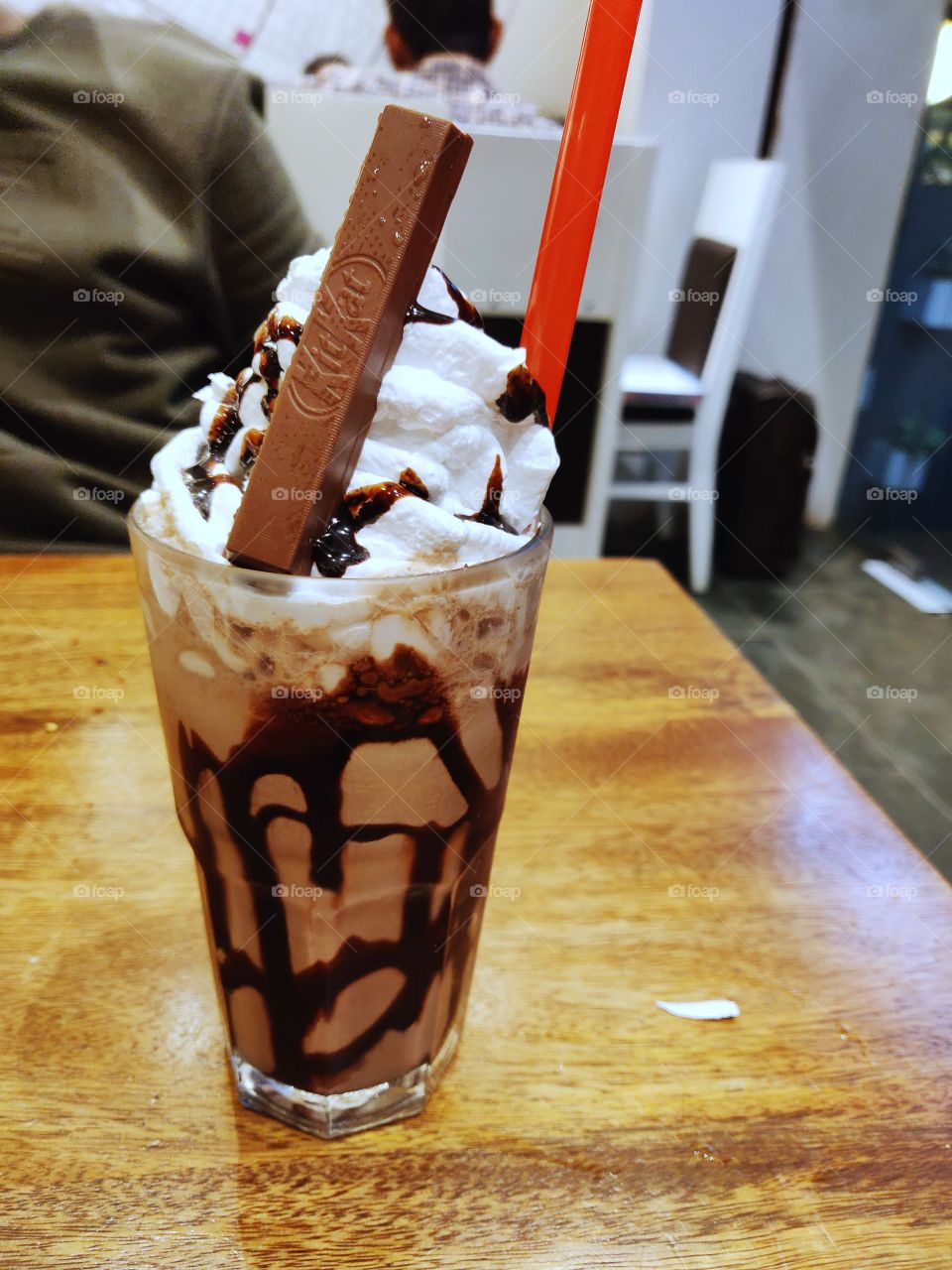 glass full of cold coffee with chocolate and topped with vanilla ice cream and a piece of KitKat