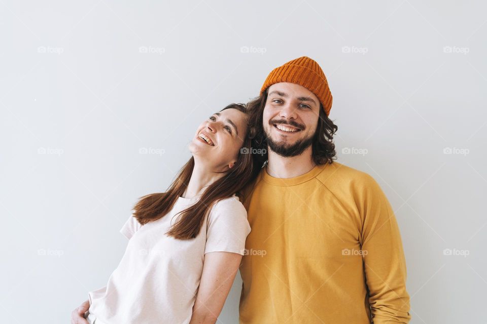 Portrait of happy couple young family laughing against the gray wall