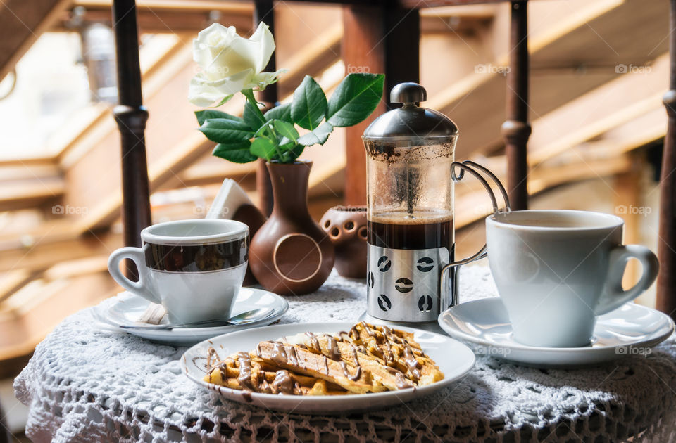 Two cup of coffee and waffles with chocolate. Tasty and traditional breakfast