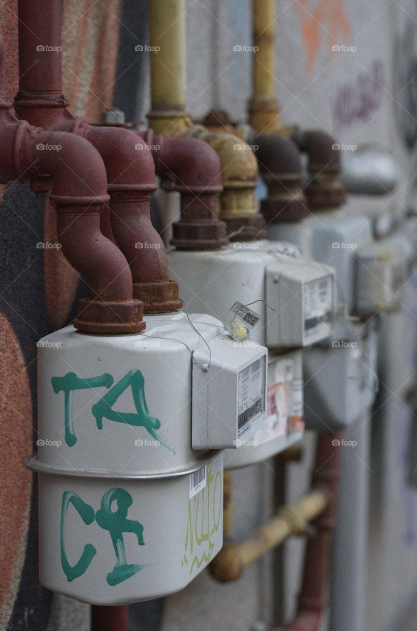 Three gray gas meters on a wall