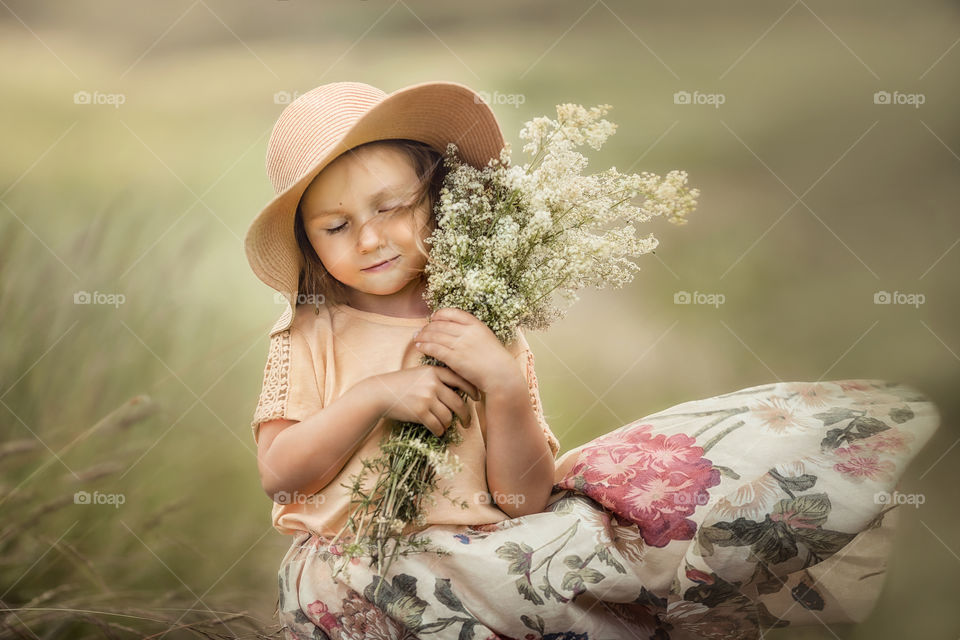 Little girl with bouquet of meadow flowers. 