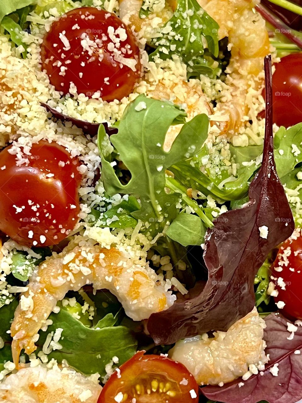Salad with shrimp, arugula and tomatoes sprinkled with Parmesan