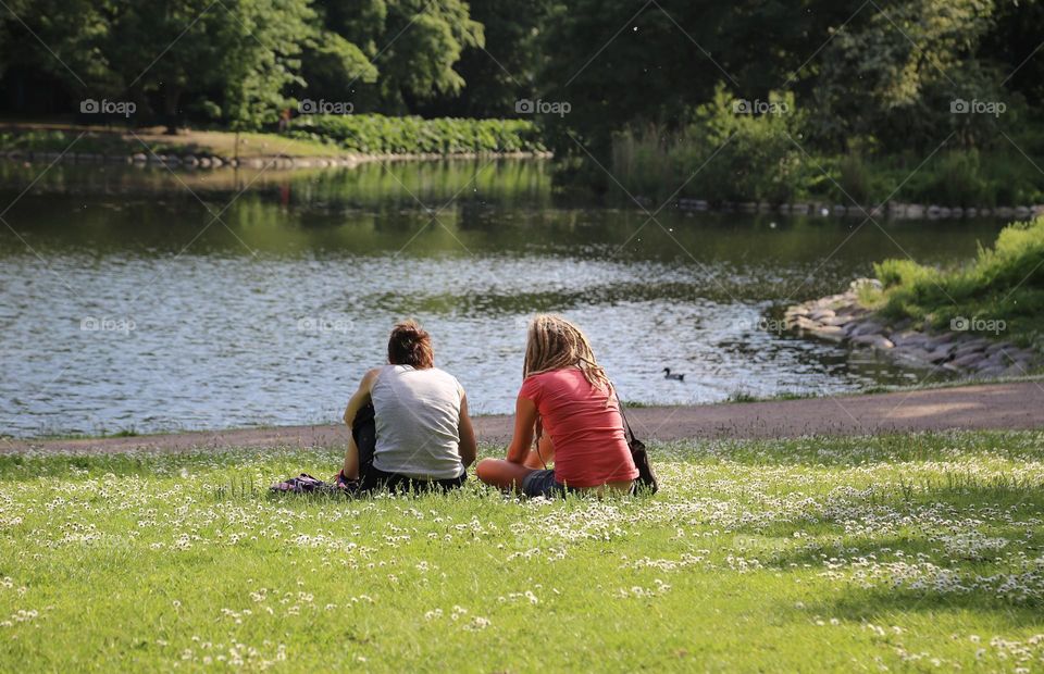 Sitting on the green grass by the canal in summertime 