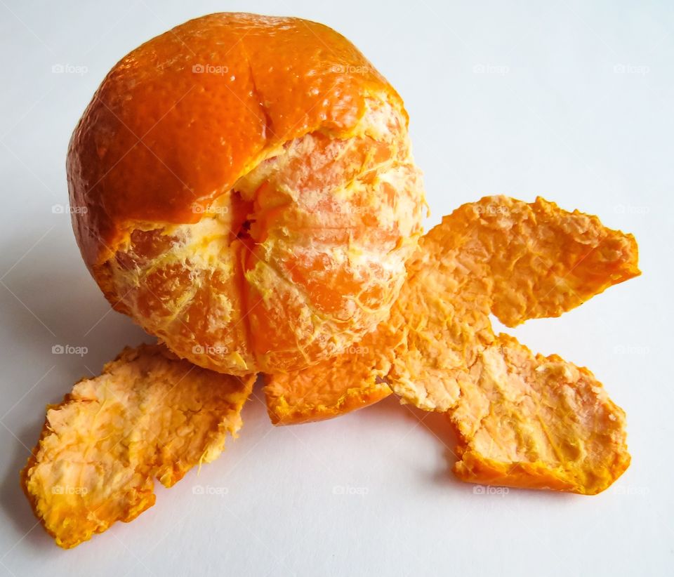A Tangerine partly peeled on a white background.