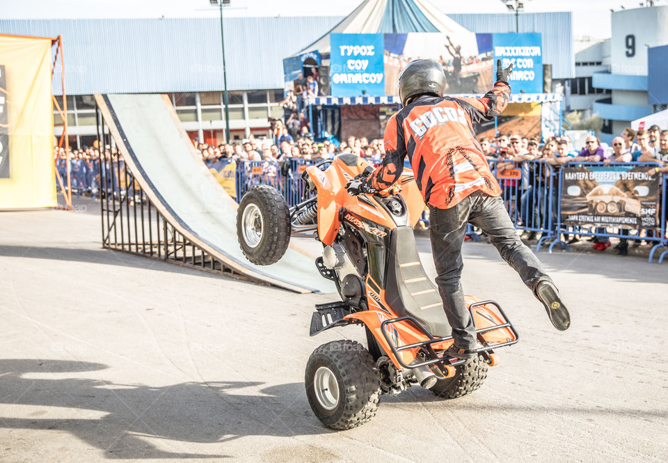 Doing Acrobatics With Quad Bike Terrain Vehicle In Front Of Crowd
