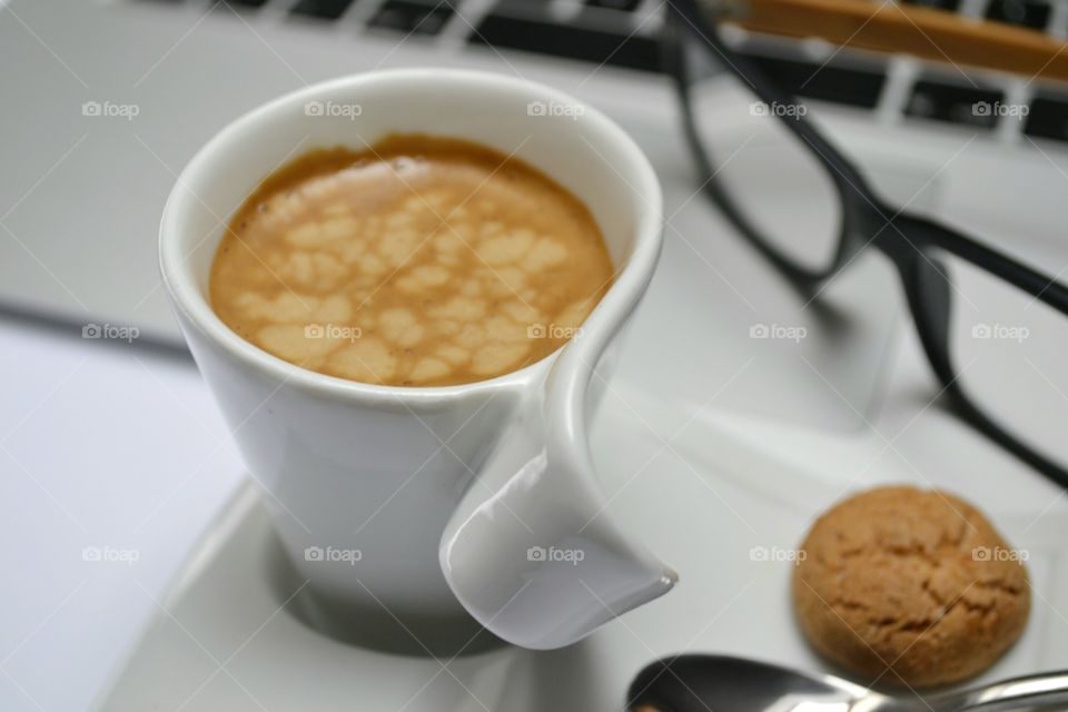 Close-up of coffee and cookie with eyeglasses