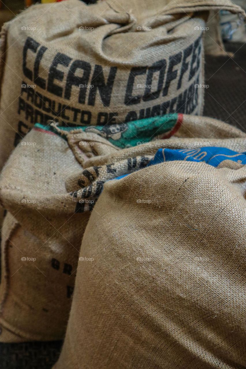 Clean coffee burlap sacks filled with delicious coffee beans waiting to be roasted and consumed 