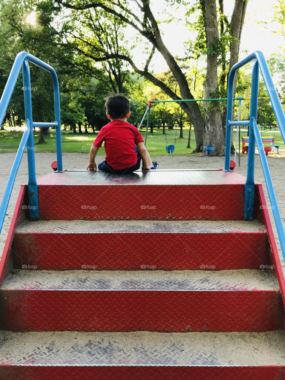 Young boy going down a slide at a park