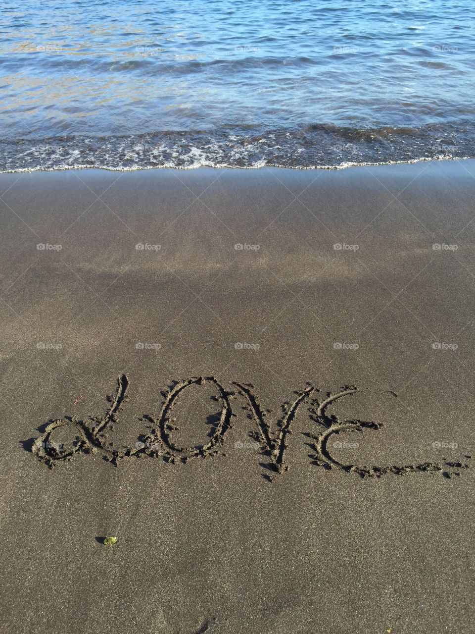 Love written on beach sand
