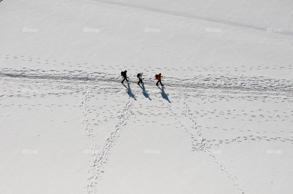 Three mountaineers traverse the glacier en route to Mont Blanc France