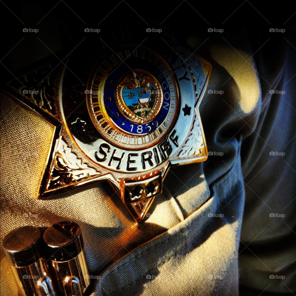 Closeup of sheriff police badge on uniform.
