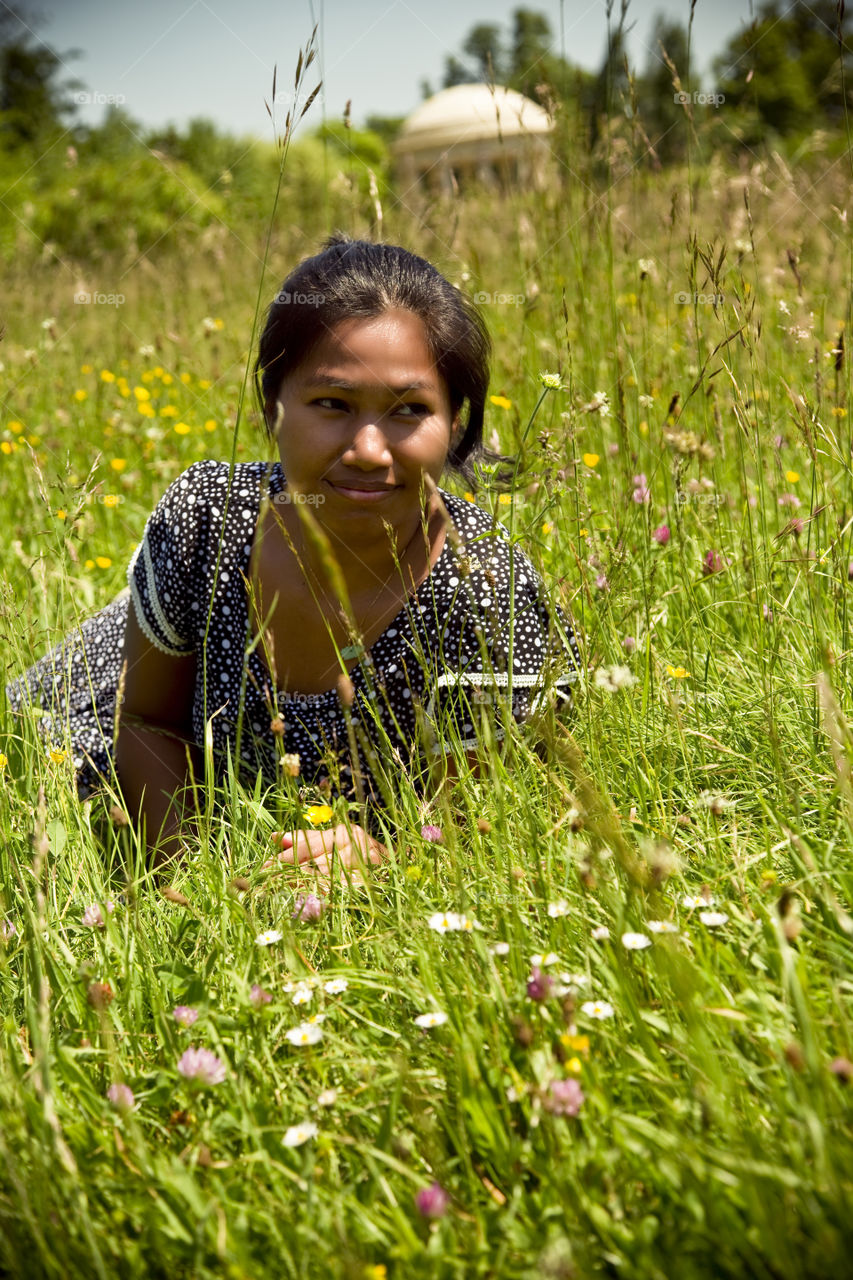 Asian lady on the grass enjoying spring. Mimi loves when spring is here and flower are blooming