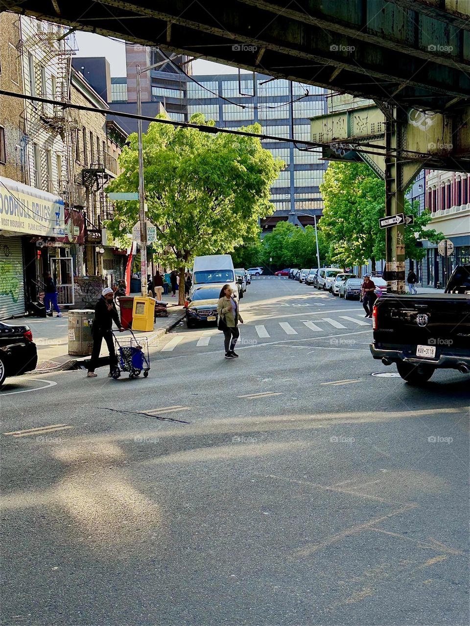 This is „Broadway“ and „Flushing Avenue“ in „Bushwick“, Brooklyn by the entrance to „Woodhull Hospital“. The MTA „M“ train overpass also runs along this intersection. 2024. Hypnotic Productions