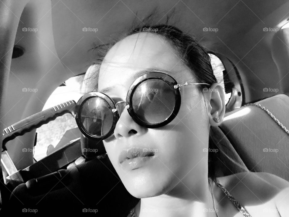 A woman wearing sunglasses in a car