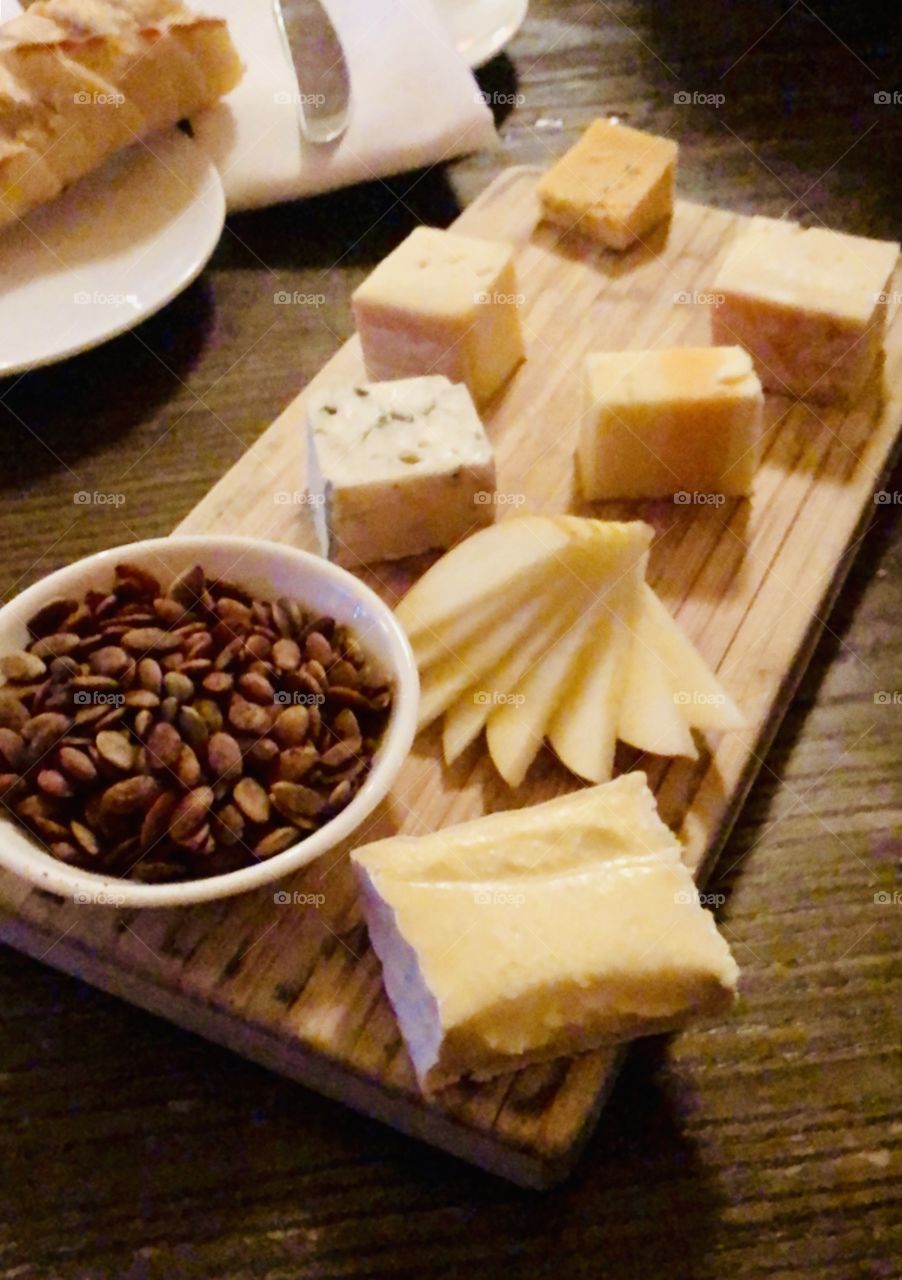 Delicious cheese board, complete with roasted nuts and apple slices. 