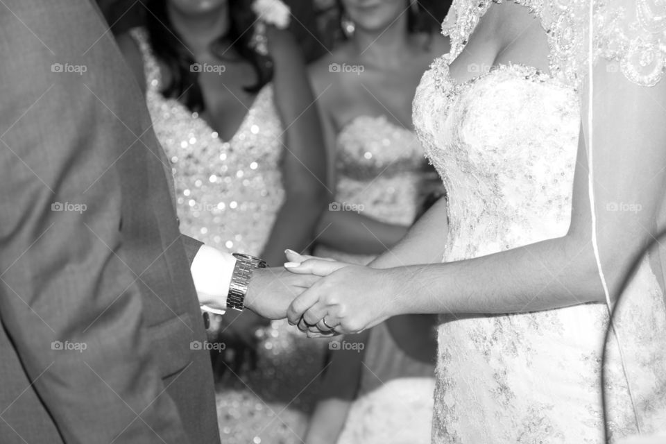 bride holding the groom's hand
after placing the wedding ring