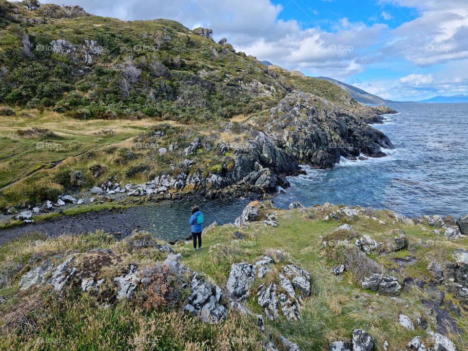 river joining the sea, cliffs with vegetation.