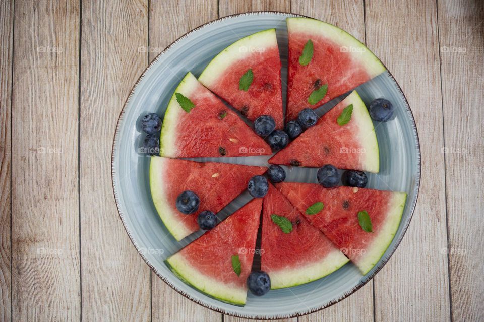 watermelon cut into wedges on wooden table