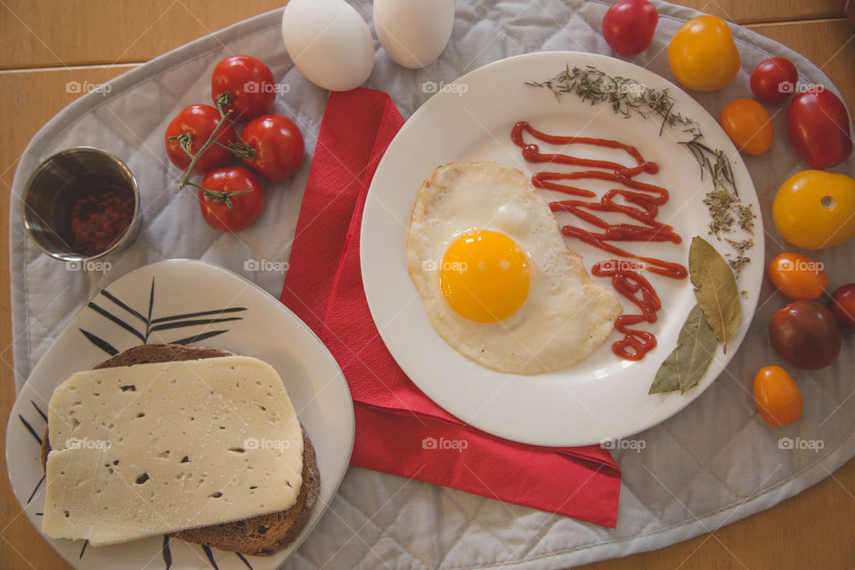 Egg, tomatoes, bread and cheese in a beautiful bright flat lay