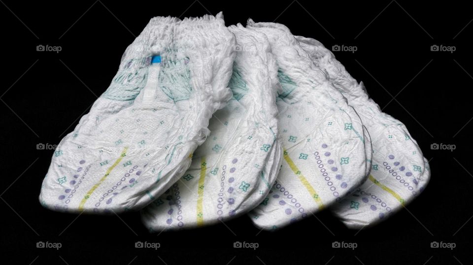 Baby diapers stacked each other on isolated background.