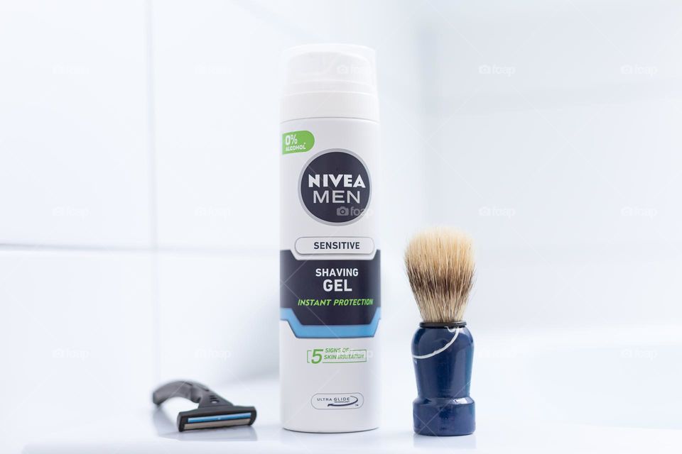 Closeup of Nivea Men sensitive shaving gel with razor and brush in the bathroom 