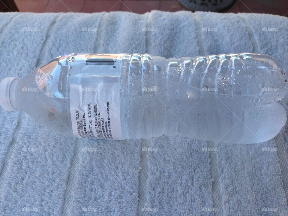 A water bottle sweating in the summer heat.