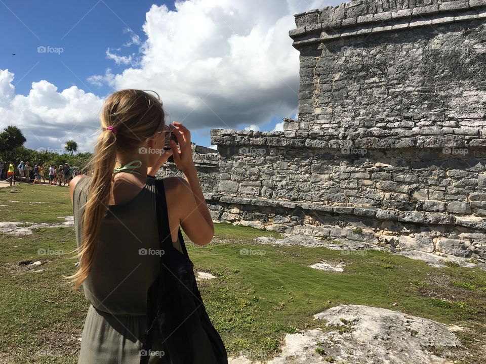 Girl takes a photo of Tulum ruins. Yucatán. 
