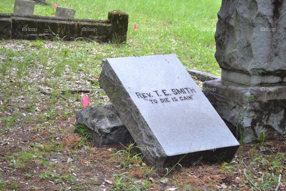 A broken tombstone of a reverend with inspirational quote