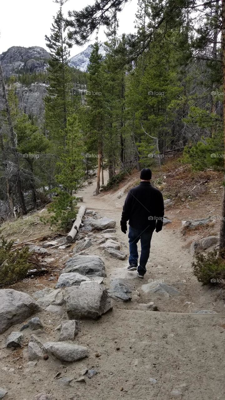 a male hiking down a trail in Colorado during Autumn