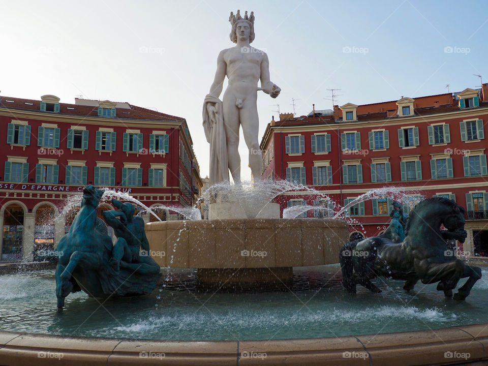 Sun fountain with statue of Apollo and mythological bronze figures on the Place Massena in Nice, France.