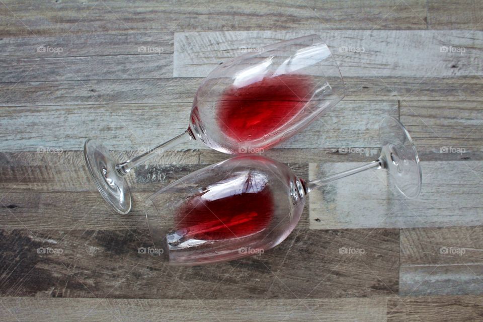 Two glasses of red wine on wooden table.