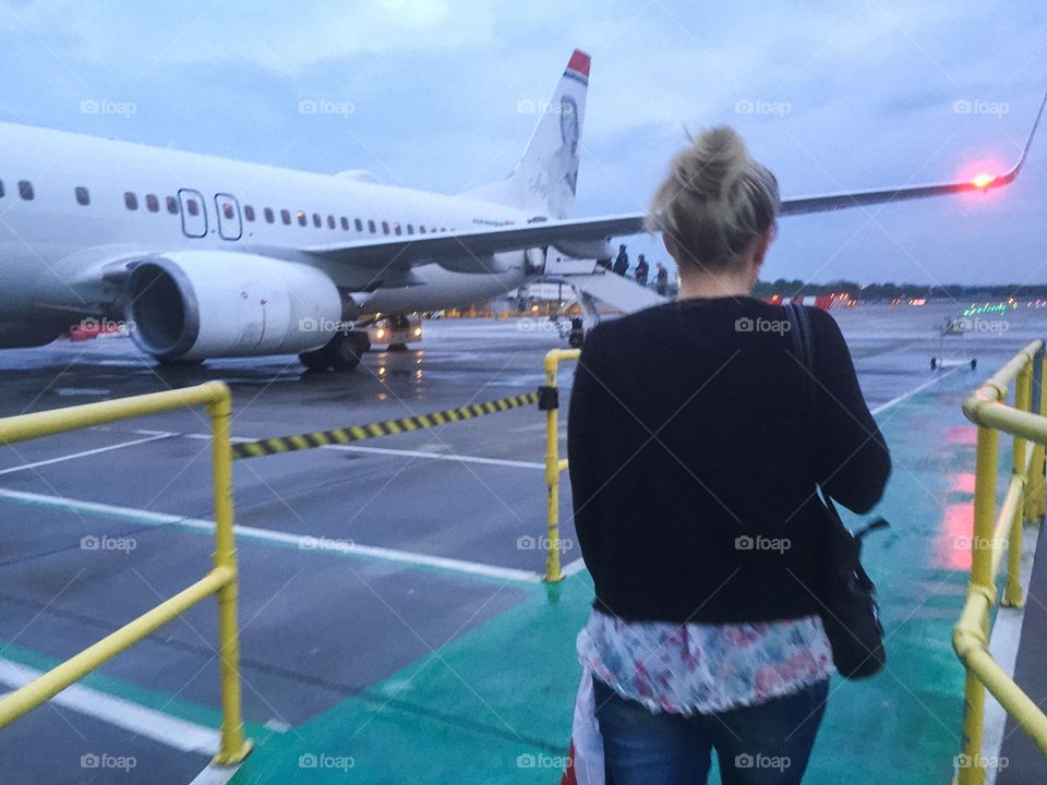 People getting on a airplane at Gatwick airport in London.